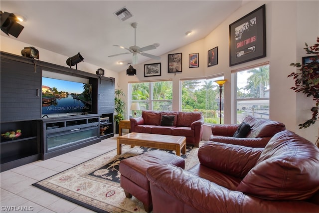 tiled living room featuring ceiling fan, a wealth of natural light, and lofted ceiling