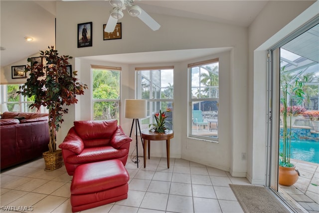 living area featuring ceiling fan, light tile floors, and lofted ceiling