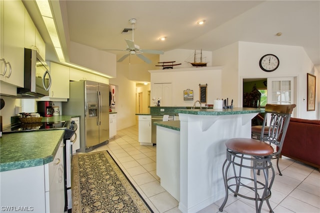 kitchen featuring a kitchen breakfast bar, appliances with stainless steel finishes, ceiling fan, and light tile floors