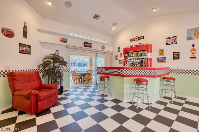 interior space featuring light tile flooring and lofted ceiling