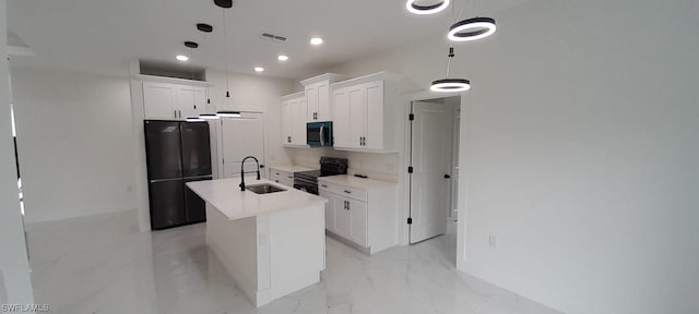 kitchen with decorative light fixtures, black appliances, a kitchen island with sink, sink, and white cabinets