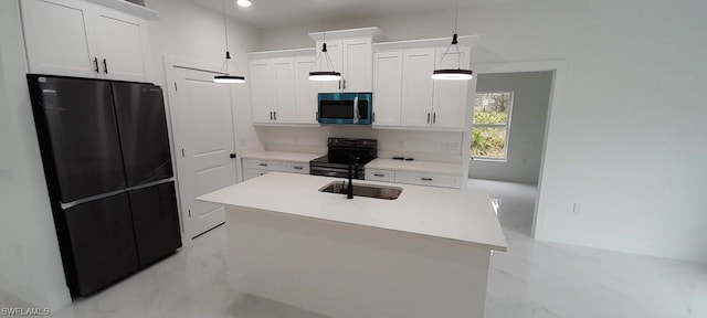 kitchen featuring white cabinetry, hanging light fixtures, black appliances, sink, and an island with sink