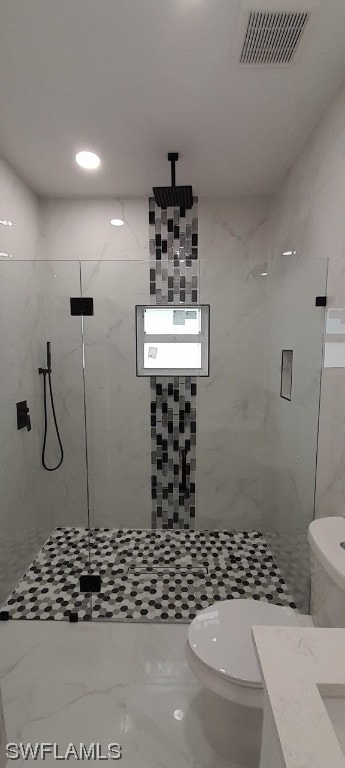 bathroom featuring tile walls, toilet, and a tile shower