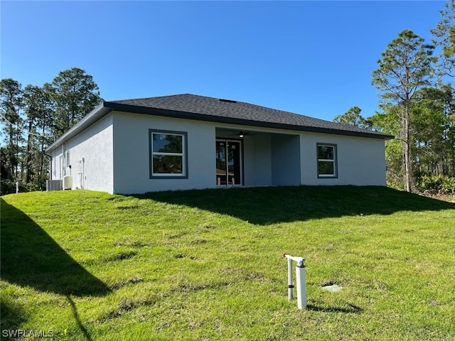 ranch-style home featuring a front lawn, ceiling fan, and central air condition unit