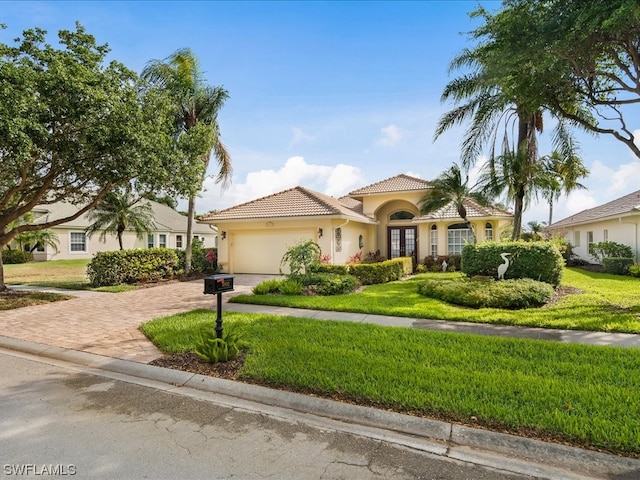 mediterranean / spanish home with a front lawn and a garage