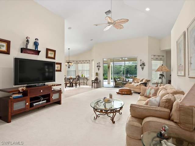 carpeted living room featuring high vaulted ceiling and ceiling fan with notable chandelier