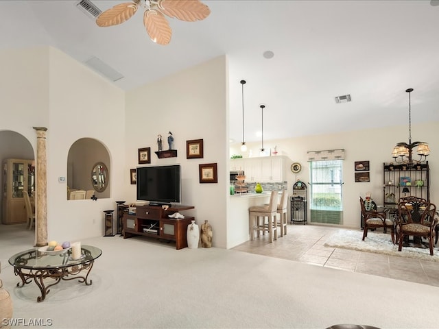 living room featuring ceiling fan, light tile floors, and a towering ceiling