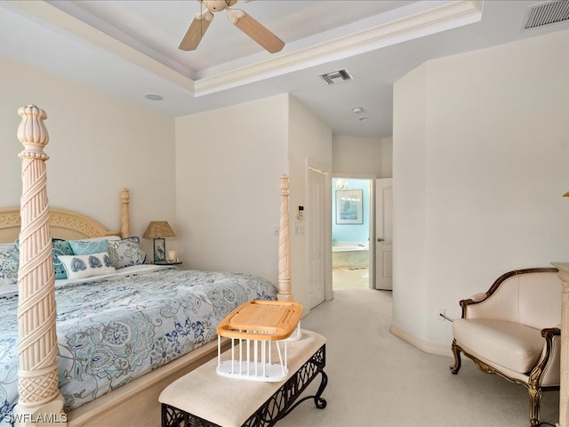 carpeted bedroom with a tray ceiling, ceiling fan, and crown molding