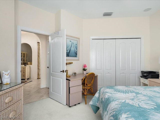 bedroom with light colored carpet and a closet