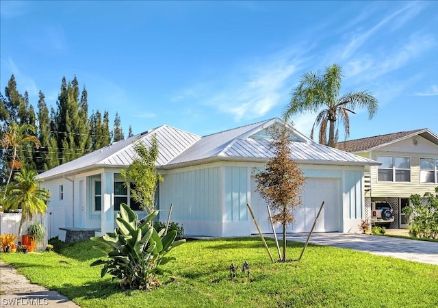 view of front of home with a front lawn, aphalt driveway, metal roof, an attached garage, and a standing seam roof