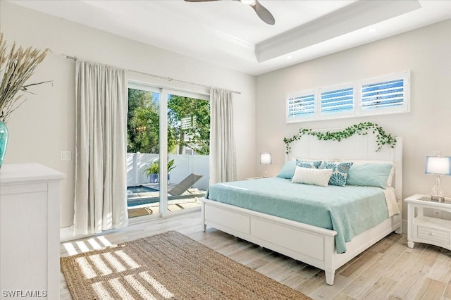 bedroom featuring access to exterior, ceiling fan, ornamental molding, light wood-style flooring, and a raised ceiling