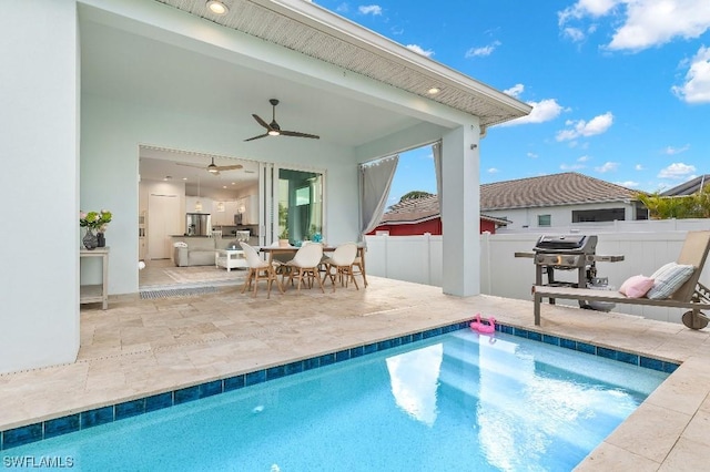 view of swimming pool featuring a patio, a fenced in pool, a ceiling fan, fence, and grilling area