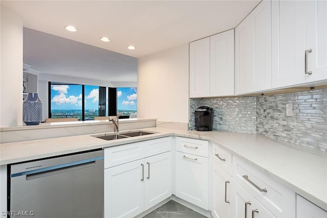 kitchen featuring sink, white cabinets, decorative backsplash, stainless steel dishwasher, and kitchen peninsula