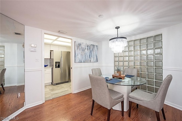 dining room with a notable chandelier and light wood-type flooring