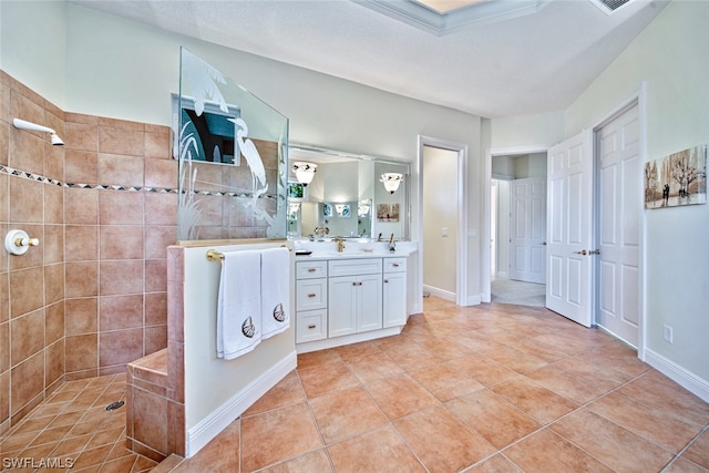 bathroom with vanity, a tile shower, and tile patterned floors