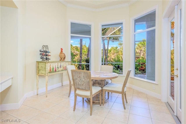dining space featuring light tile patterned floors, baseboards, and crown molding