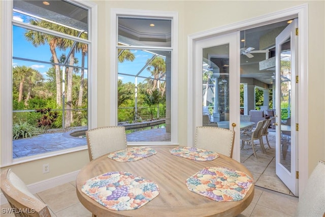 tiled dining space featuring baseboards and a ceiling fan