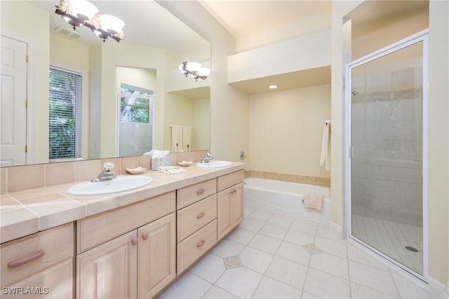 bathroom with an inviting chandelier, tile patterned floors, vanity, and separate shower and tub