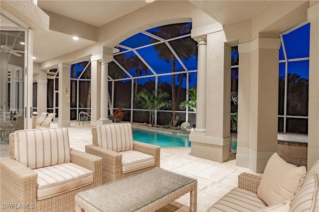 pool at night featuring a patio, a lanai, and an outdoor hangout area