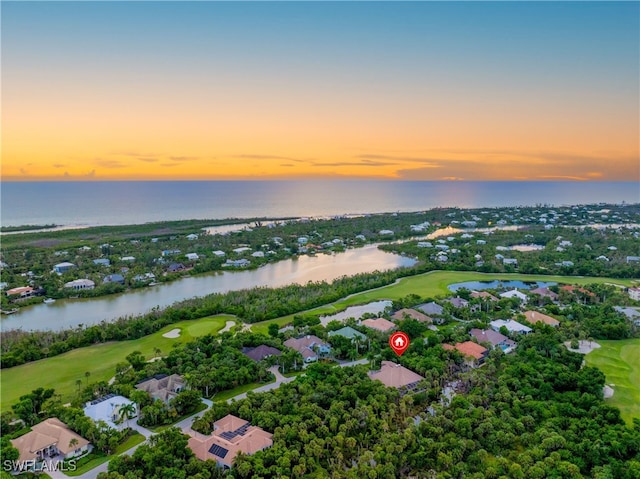 aerial view at dusk featuring a water view