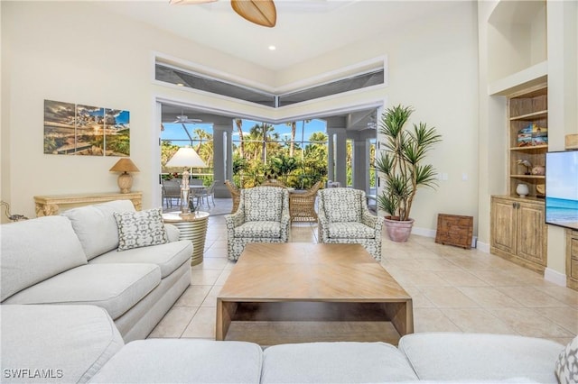 living room featuring ceiling fan, built in shelves, and light tile patterned floors