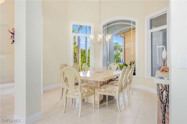 dining room featuring baseboards, arched walkways, light tile patterned floors, and a chandelier