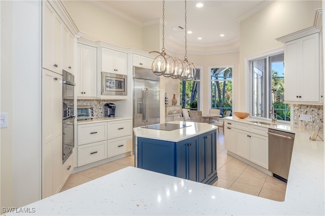 kitchen with decorative light fixtures, a kitchen island, built in appliances, and tasteful backsplash