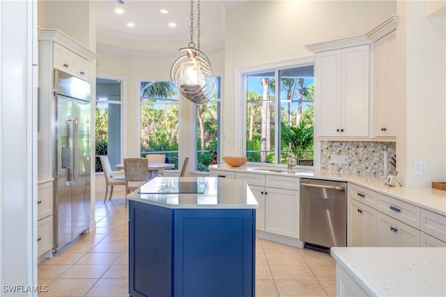 kitchen featuring decorative backsplash, stainless steel appliances, a center island, and light tile patterned floors