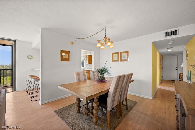 dining room with a chandelier and light wood-type flooring