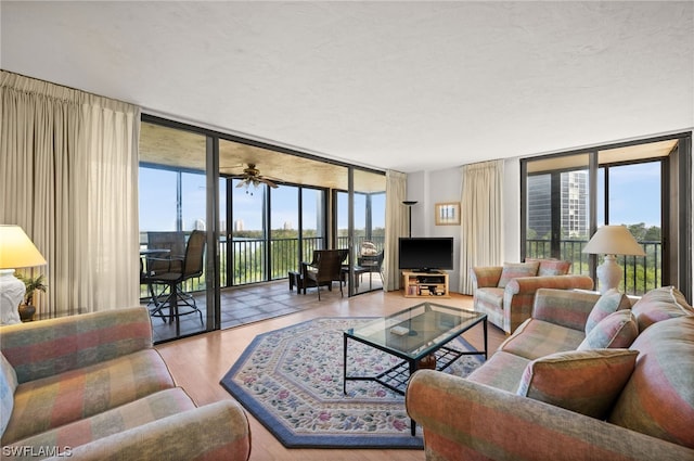 living room with expansive windows, light wood-type flooring, and ceiling fan