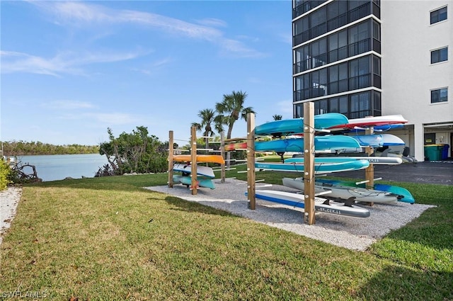 view of jungle gym featuring a water view and a lawn