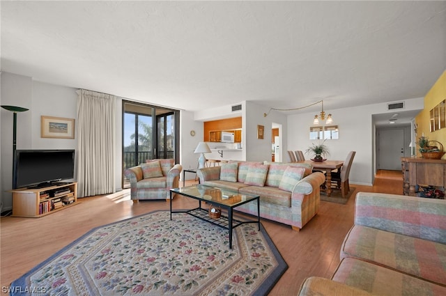 living room with a notable chandelier and light wood-type flooring