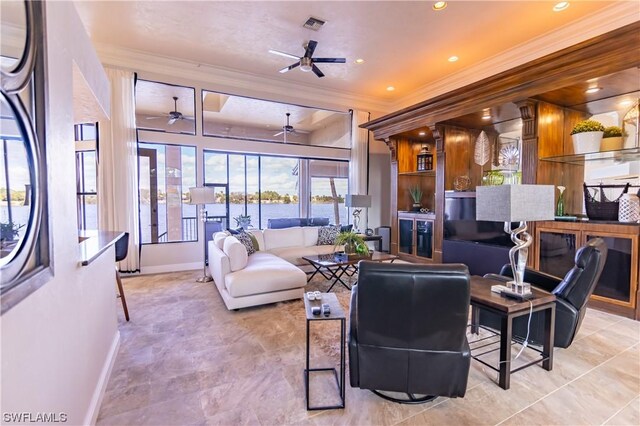 living room with ceiling fan, crown molding, and a healthy amount of sunlight