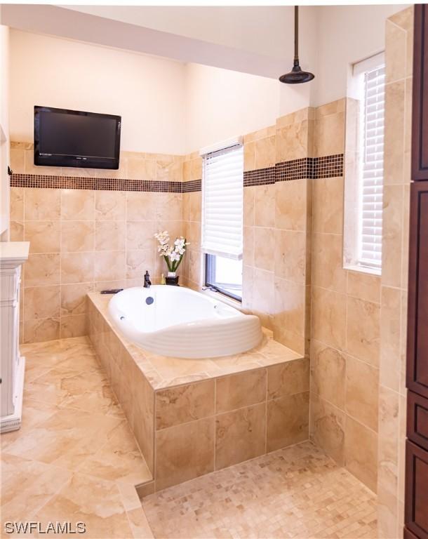 bathroom with tile walls and plus walk in shower