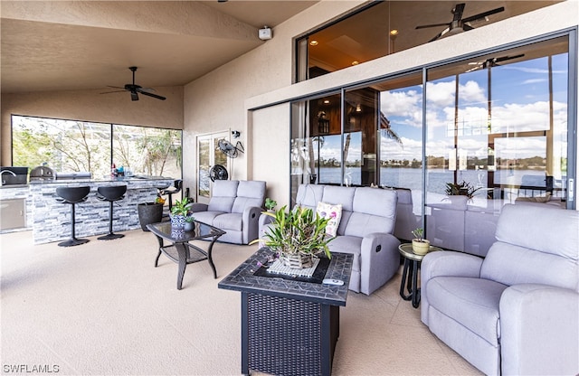 view of patio featuring a water view, area for grilling, outdoor lounge area, and ceiling fan