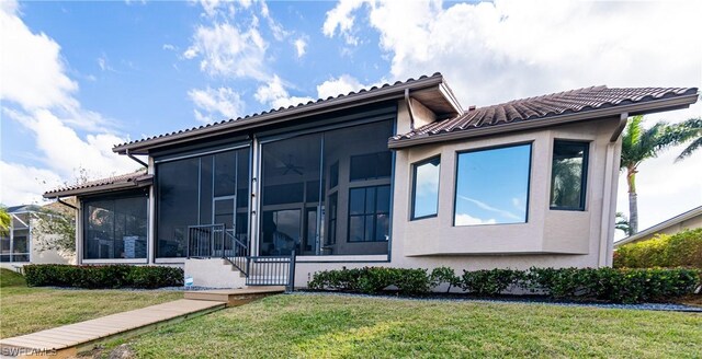 view of front of property featuring a front lawn and a sunroom