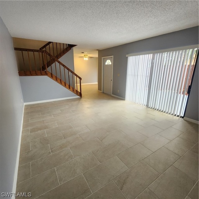 unfurnished living room featuring light tile patterned floors and a textured ceiling