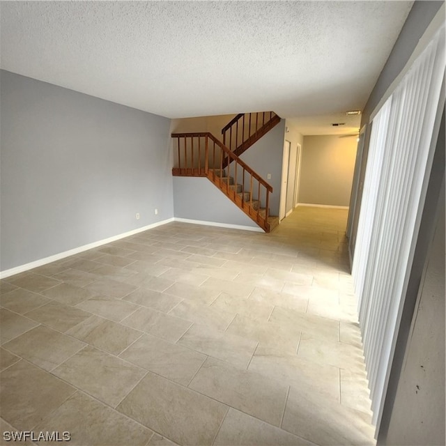 empty room with tile patterned floors and a textured ceiling