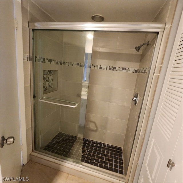 bathroom featuring walk in shower and tile patterned flooring