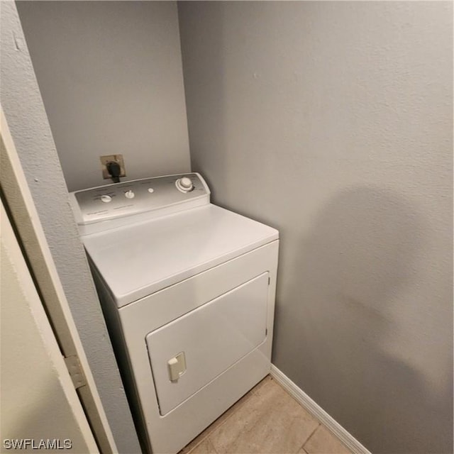 clothes washing area with laundry area, washer / dryer, and baseboards