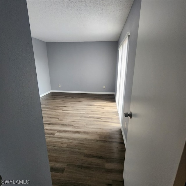 empty room featuring a textured ceiling and hardwood / wood-style floors