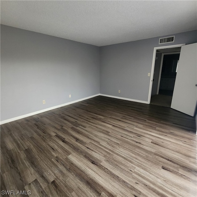 spare room featuring a textured ceiling and hardwood / wood-style floors