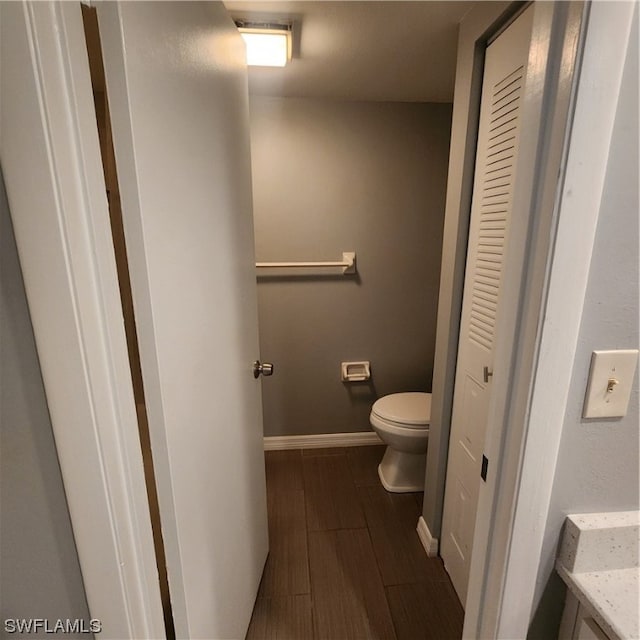 bathroom featuring toilet, vanity, and wood-type flooring