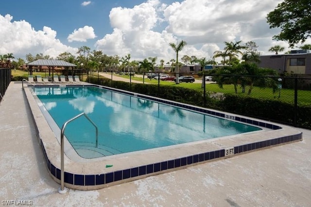 community pool with a gazebo and fence