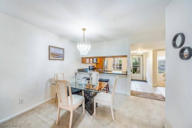 dining space with light colored carpet and a chandelier