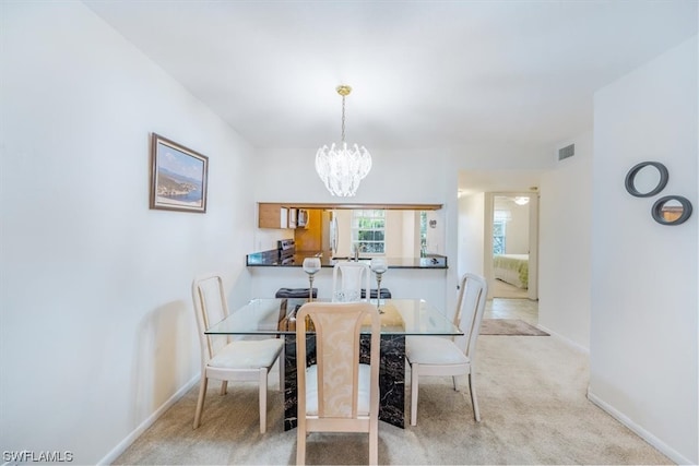 carpeted dining area featuring a notable chandelier