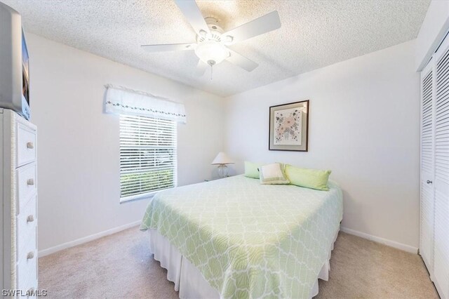 bedroom with light carpet, ceiling fan, and a closet