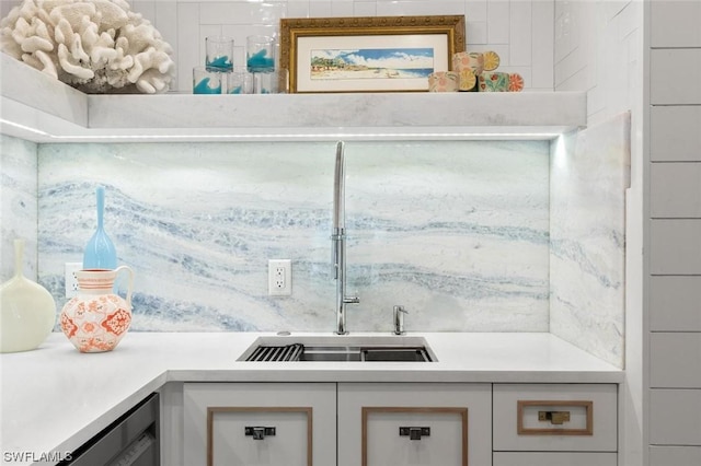 kitchen featuring white cabinetry, light countertops, and a sink