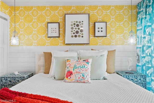 bedroom with a wainscoted wall and wallpapered walls