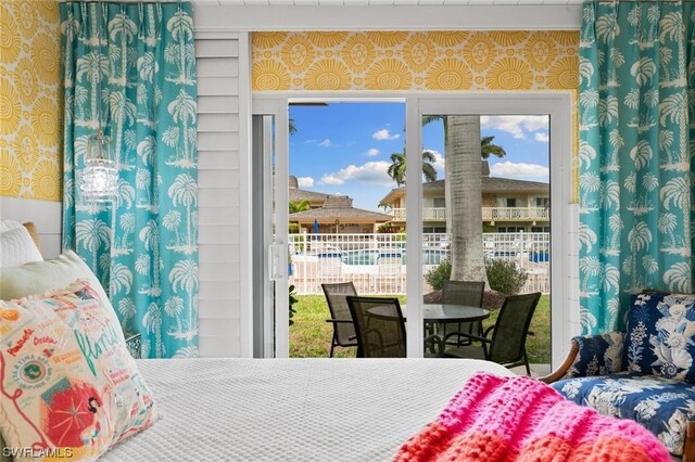 bedroom with access to outside and wallpapered walls